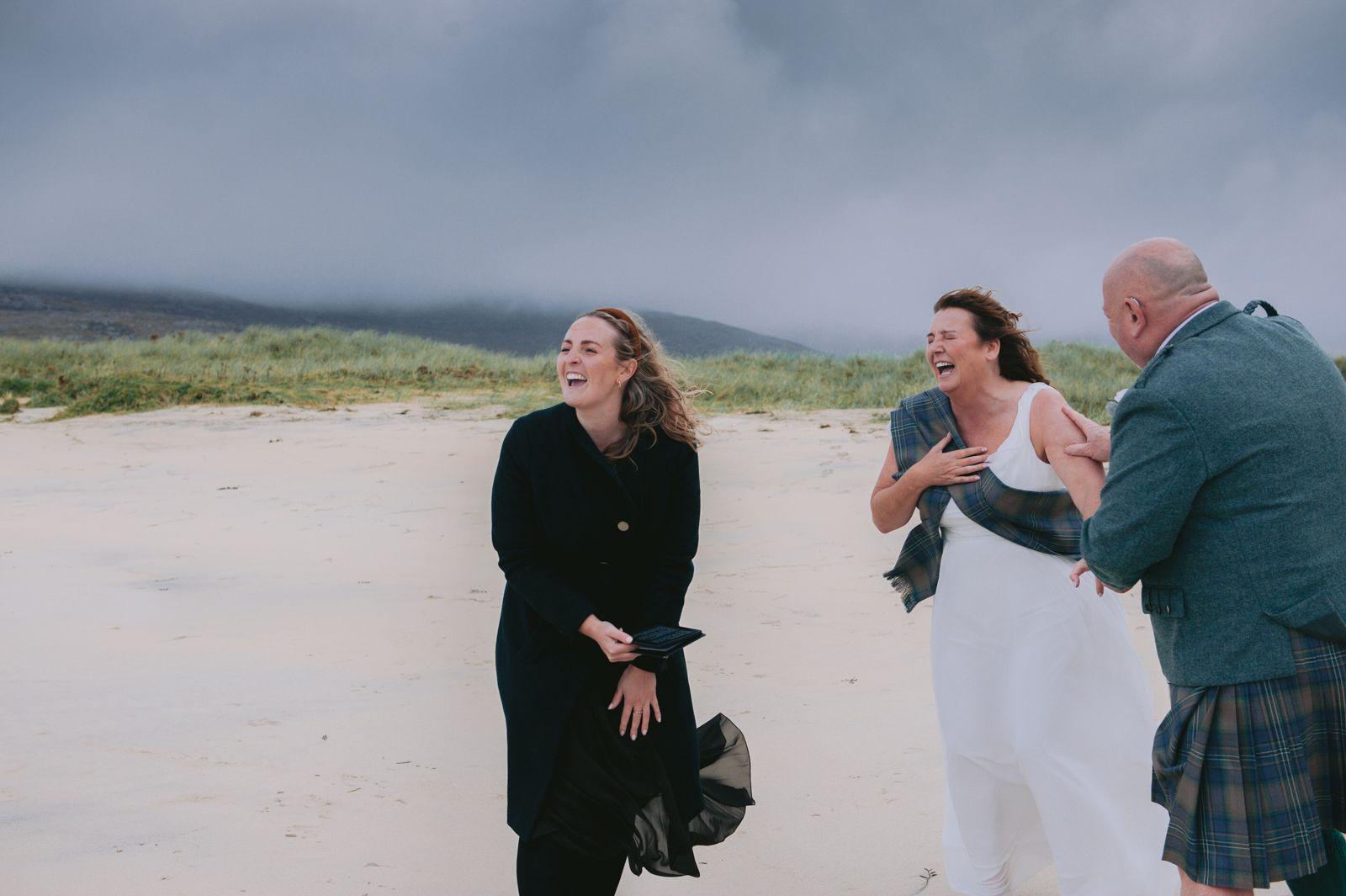 The celebrant, bride and groom laughing together at a joyful Isle of Harris humanist wedding