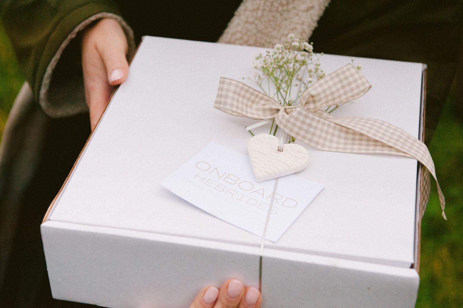 A wedding picnic box from On Board Hebrides tied with gingham ribbon and gypsophila