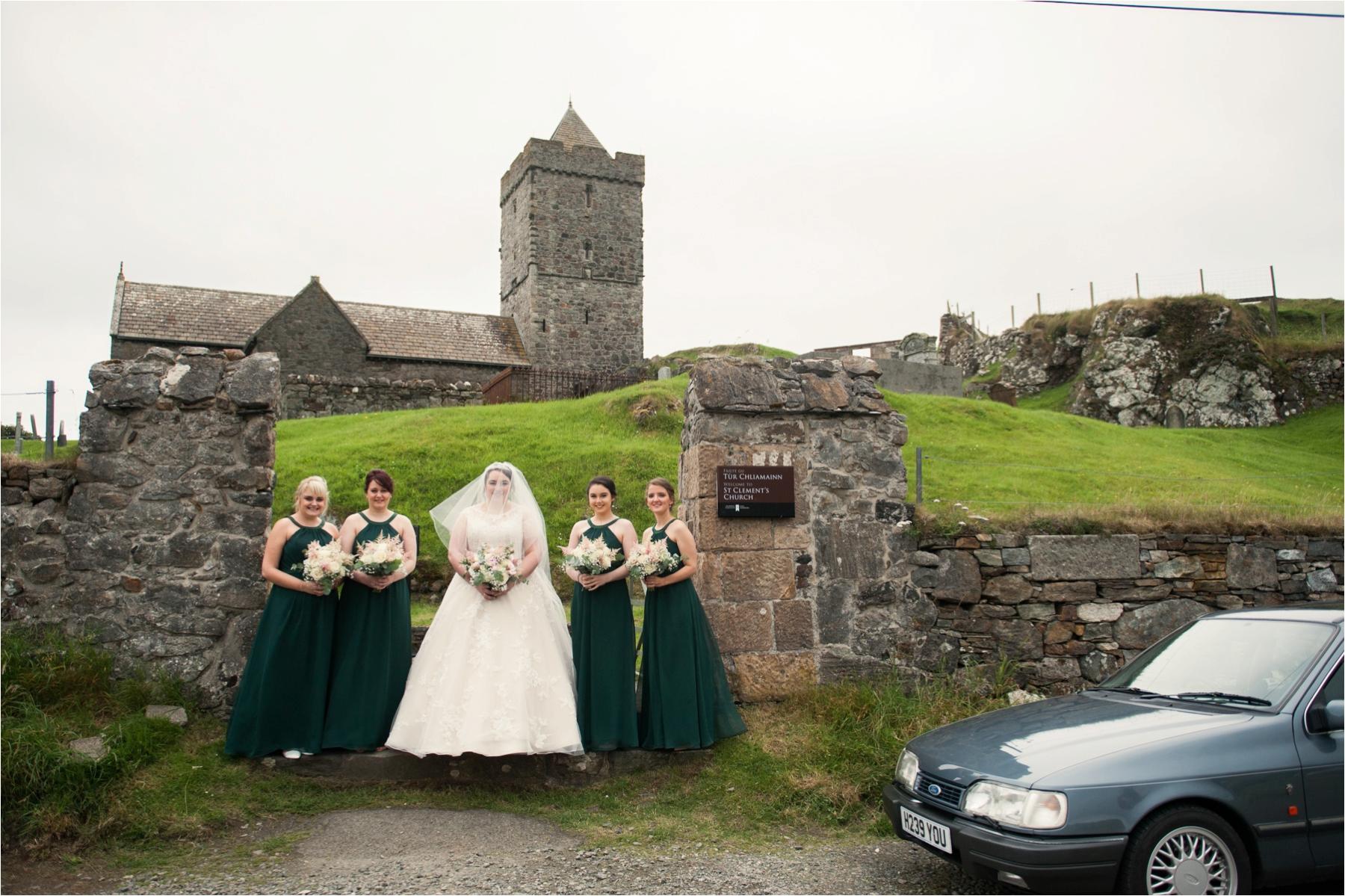 Bride Lauren and her bridesmaids pose together for a portrait in front of St Clements in Rodel on the Isle of Harris. 