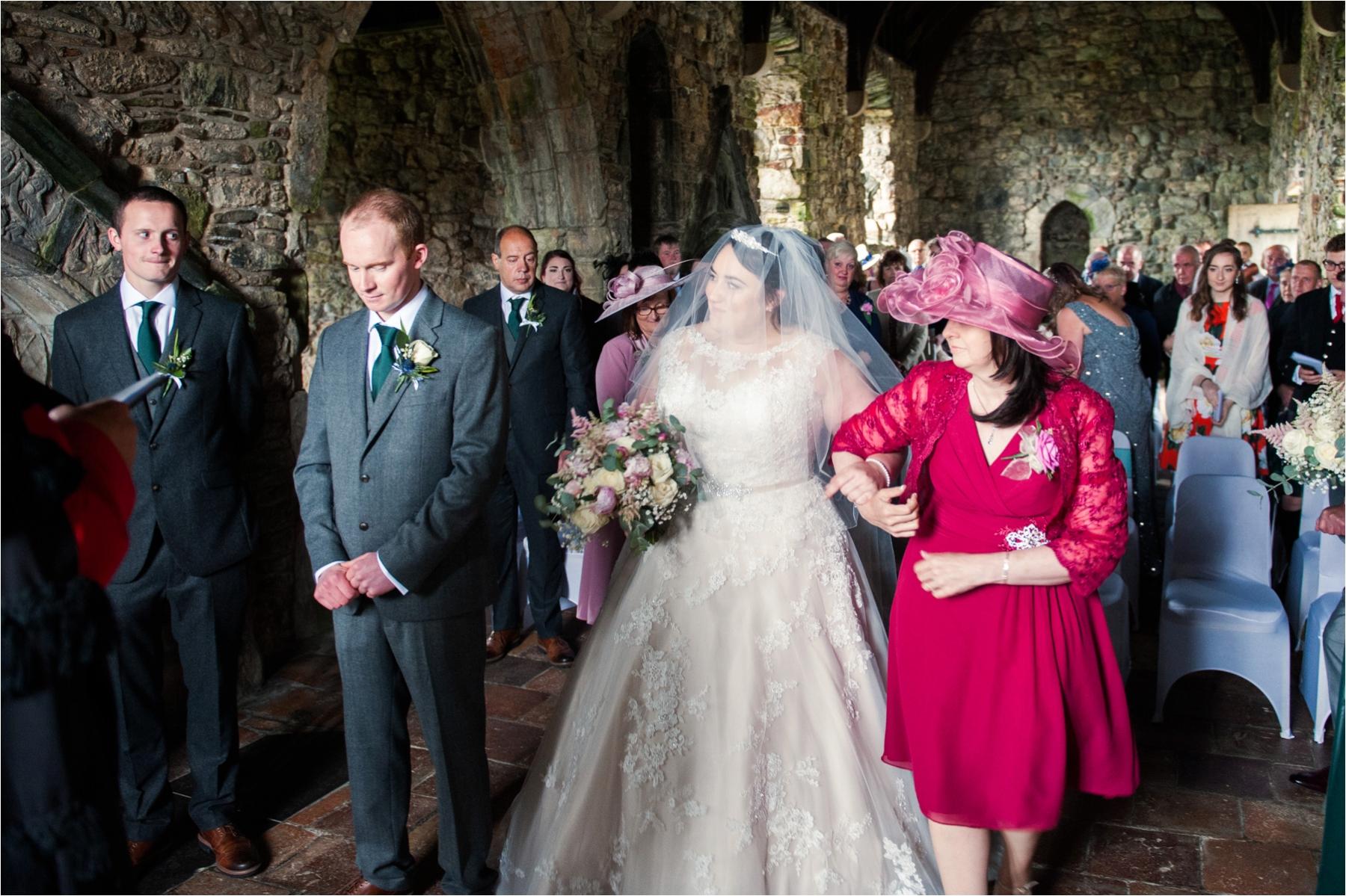 Bride Lauren walks up the aisle on the arm of her mother, ready to meet groom Michael, in St Clements Church, Rodel, on the Isle of Harris. 