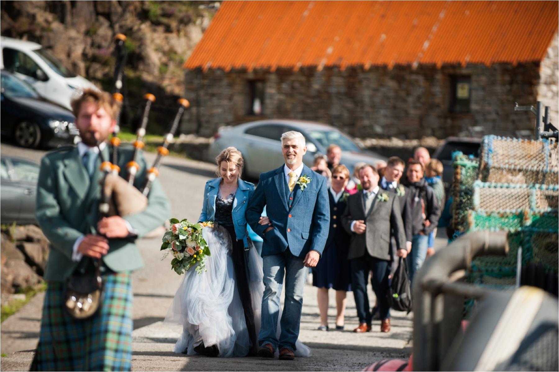 The bride and groom are piped aboard the Misty Isle boat for a trip with their wedding guests on the Isle of Skye. 