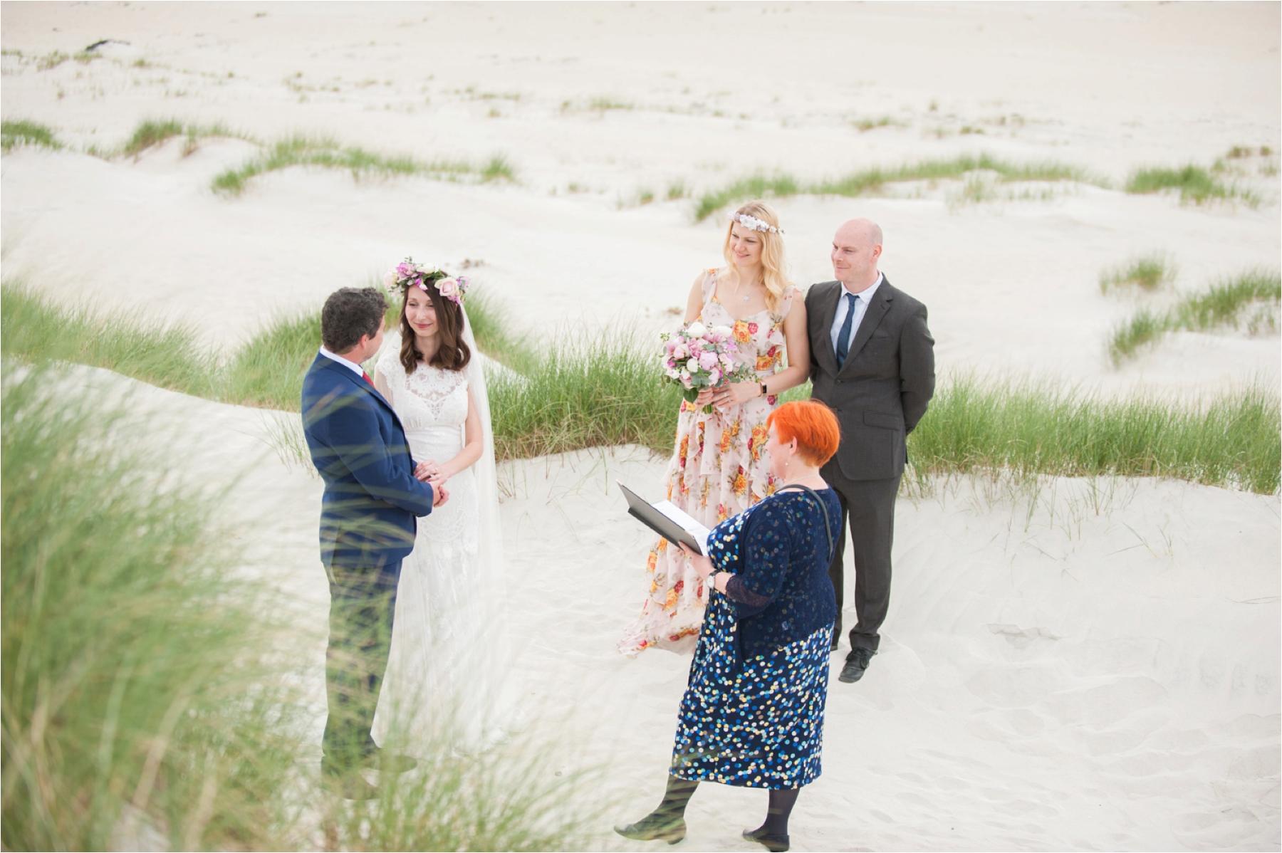 Bride and groom Ilona and Emil exchange vows in front of two friends during their elopement on Luskentyre Beach with celebrant Helen Mayer.