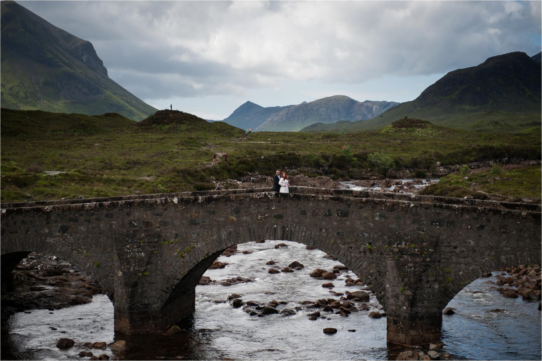 A couple stands on the old bridge at Sligachan on the Isle of Skye, where their outdoor wedding ceremony took place. 