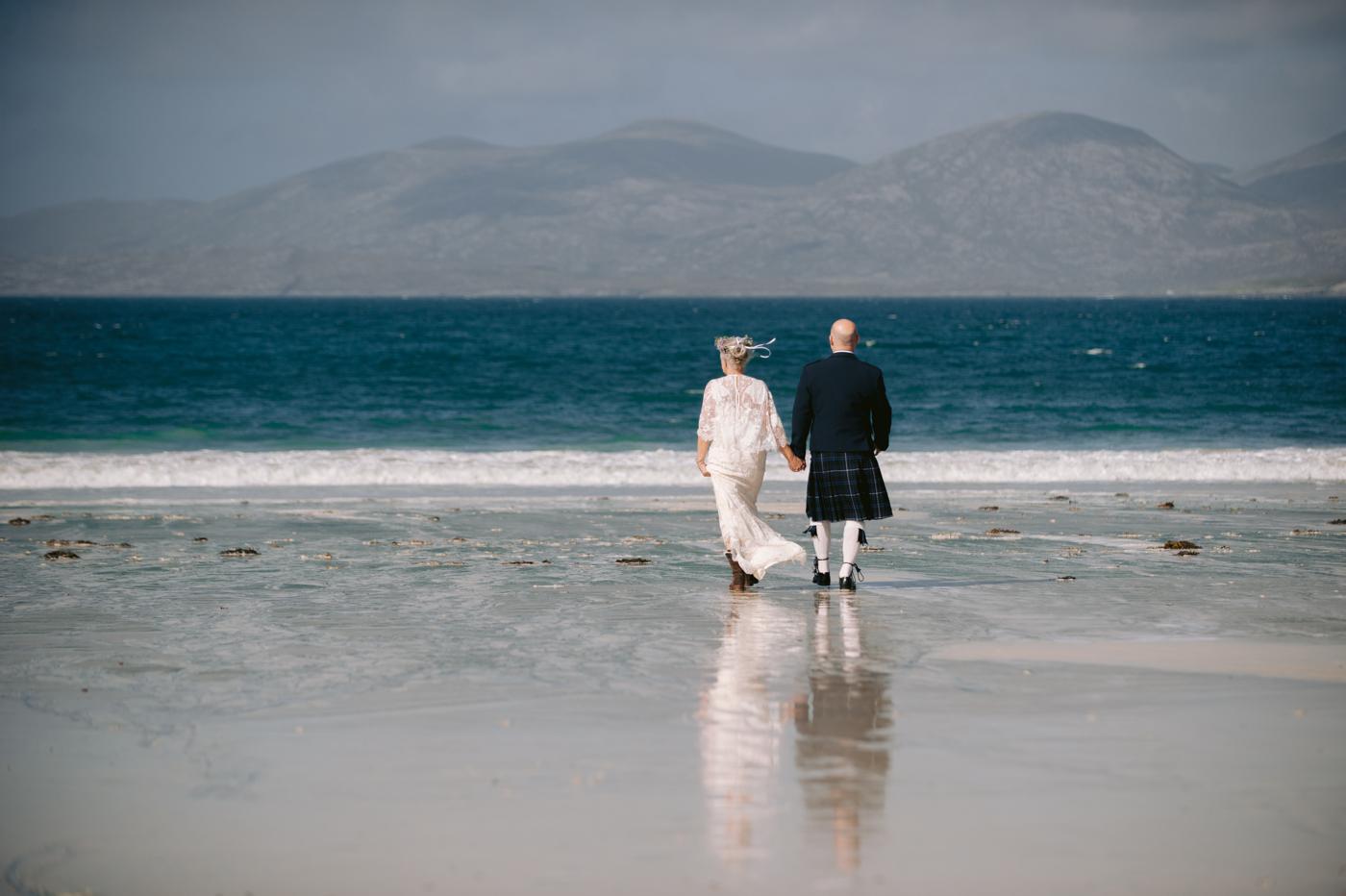 Bride and groom at the water's edge, Luskentyre Beach