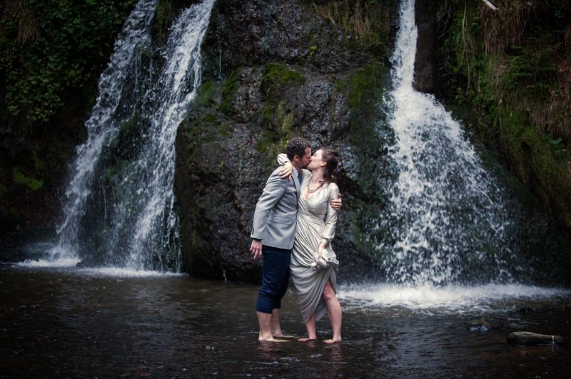 Outdoor wedding in the Scottish Highlands - a couple kissing in the rain.