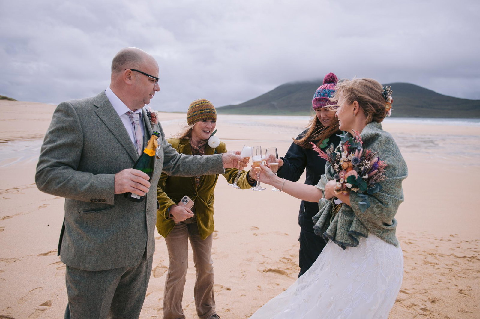 Bride and groom sharing a champagne toast with their witnesses on Scarista Beach, Isle of Harris