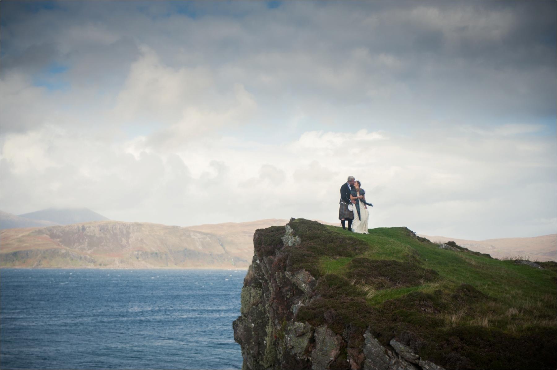 A clifftop wedding photo on the Isle of Skye near Dunscaith Castle. The bride and groom had a humanist ceremony outdoors amidst rain. 