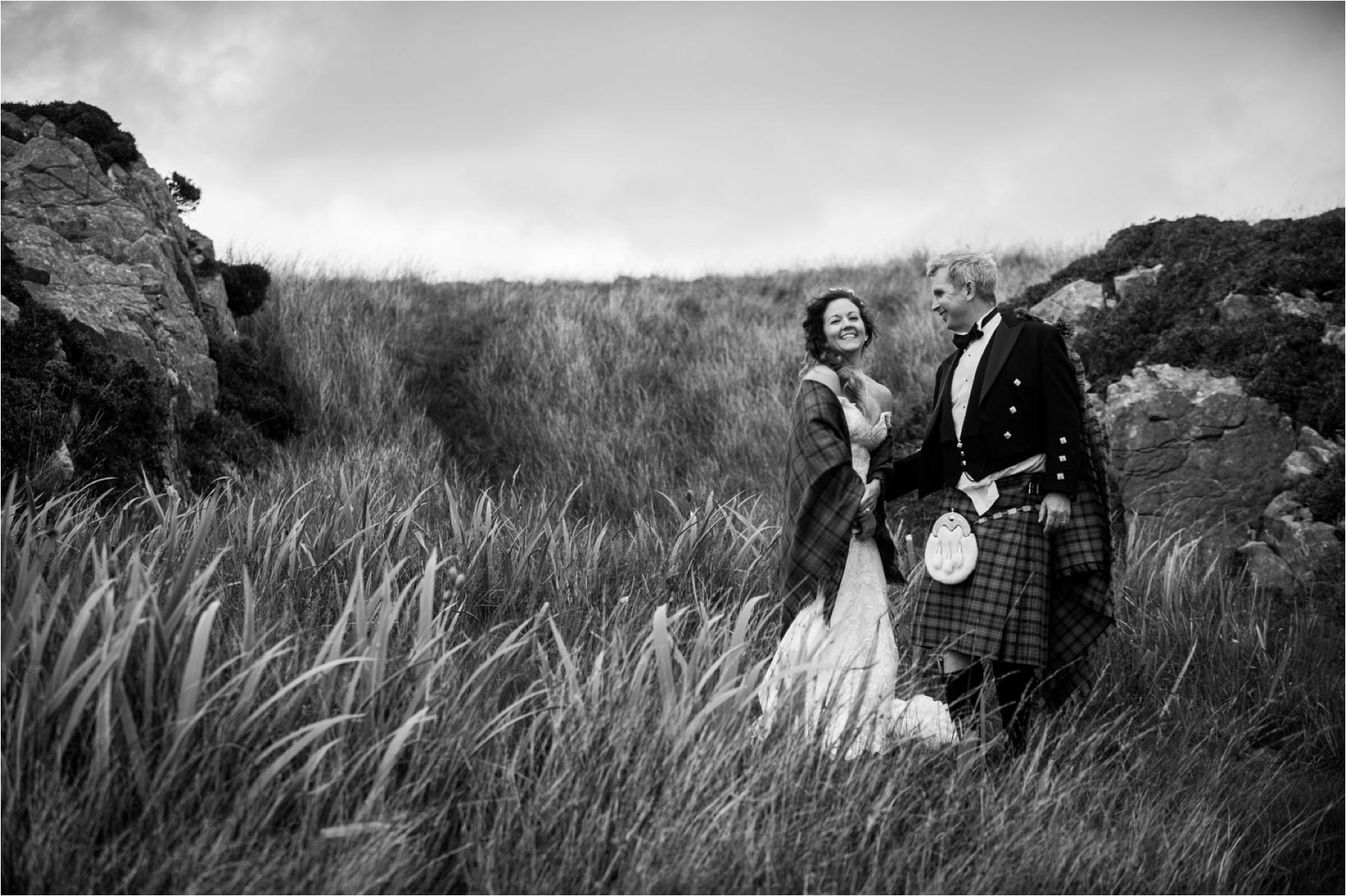 A black and white photo of a bride and groom just after they exchanged vows in a humanist ceremony at Dunscaith Castle ruins. 