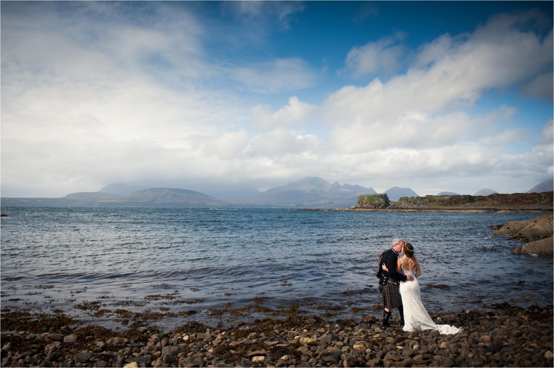 A loch-side wedding portrait of a bride and groom with blue skies. They had a humanist wedding ceremony. 