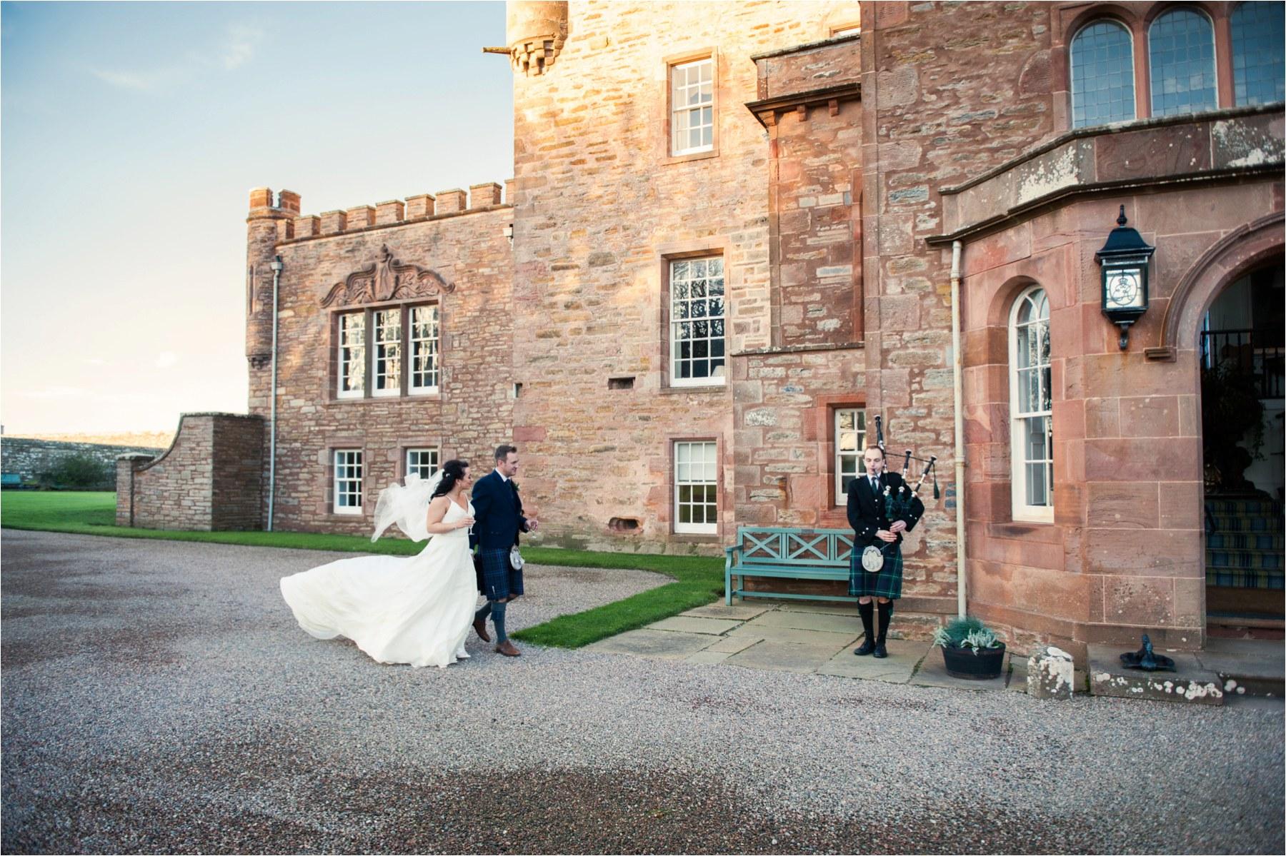 couple being piped in to castle of mey wedding scotland